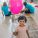 A photograph of a little girl with a pink balloon