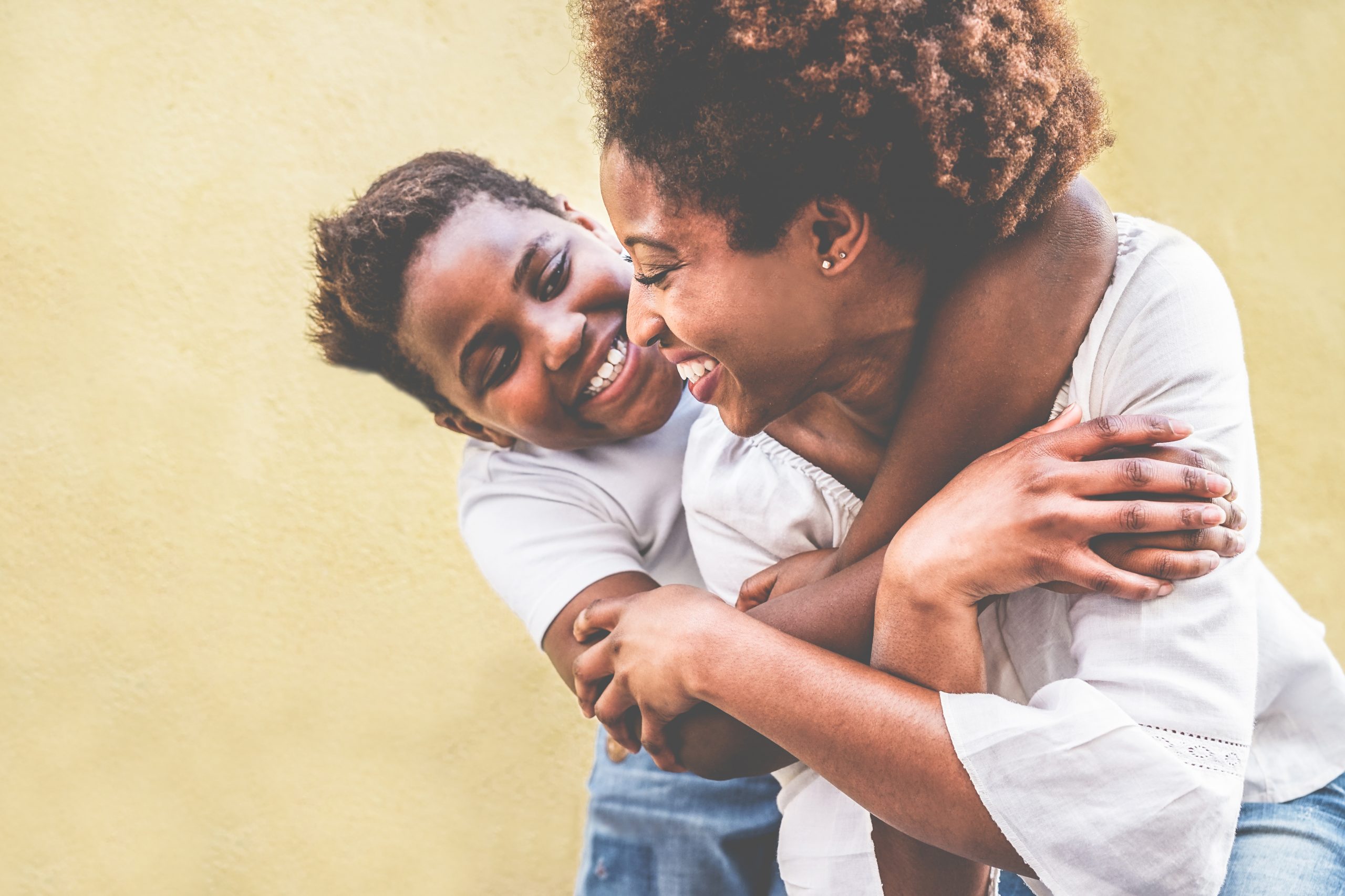 Happy young mother having fun with her kid – Son hugging his mum outdoor – Family connection, motherhood, love and tender moments concept – Focus on woman eye Ten things asylum seekers in Wales need to know