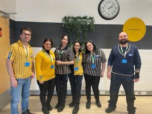 A photograph of six refugees in Ikea uniform.