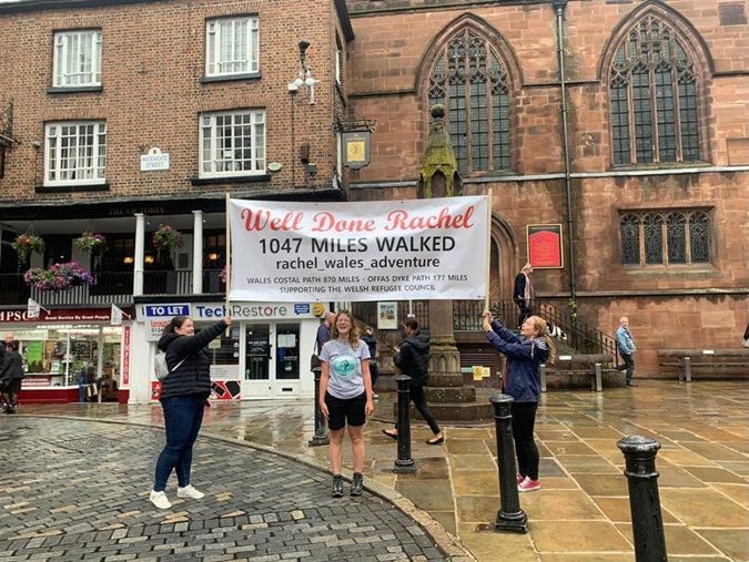 A photograph of two people holding up a sign that says 