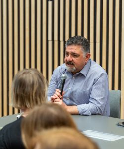 Heewr talking into a microphone at the Welsh Refugee Council Annual General Meeting.