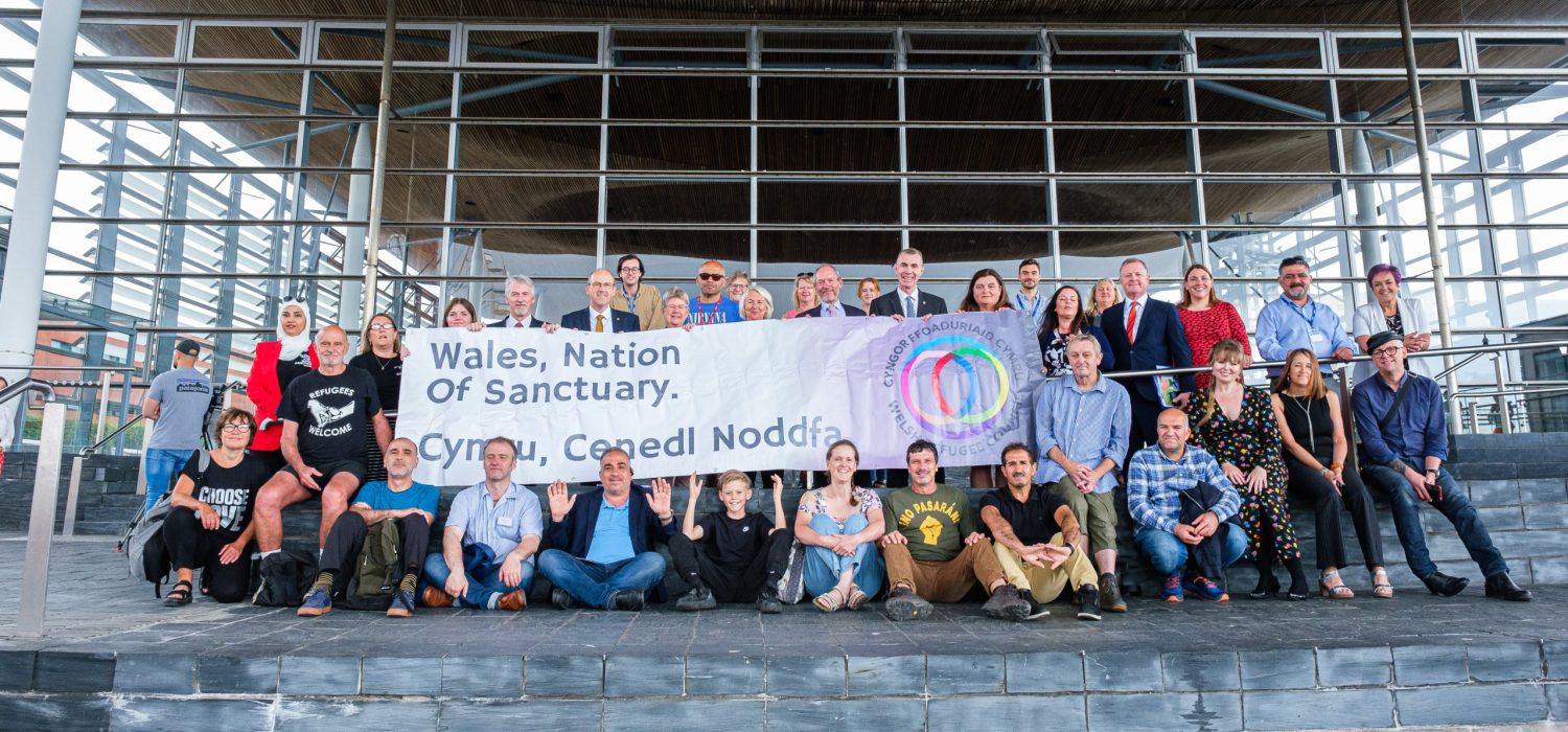 Group of people sat outside the Senedd.