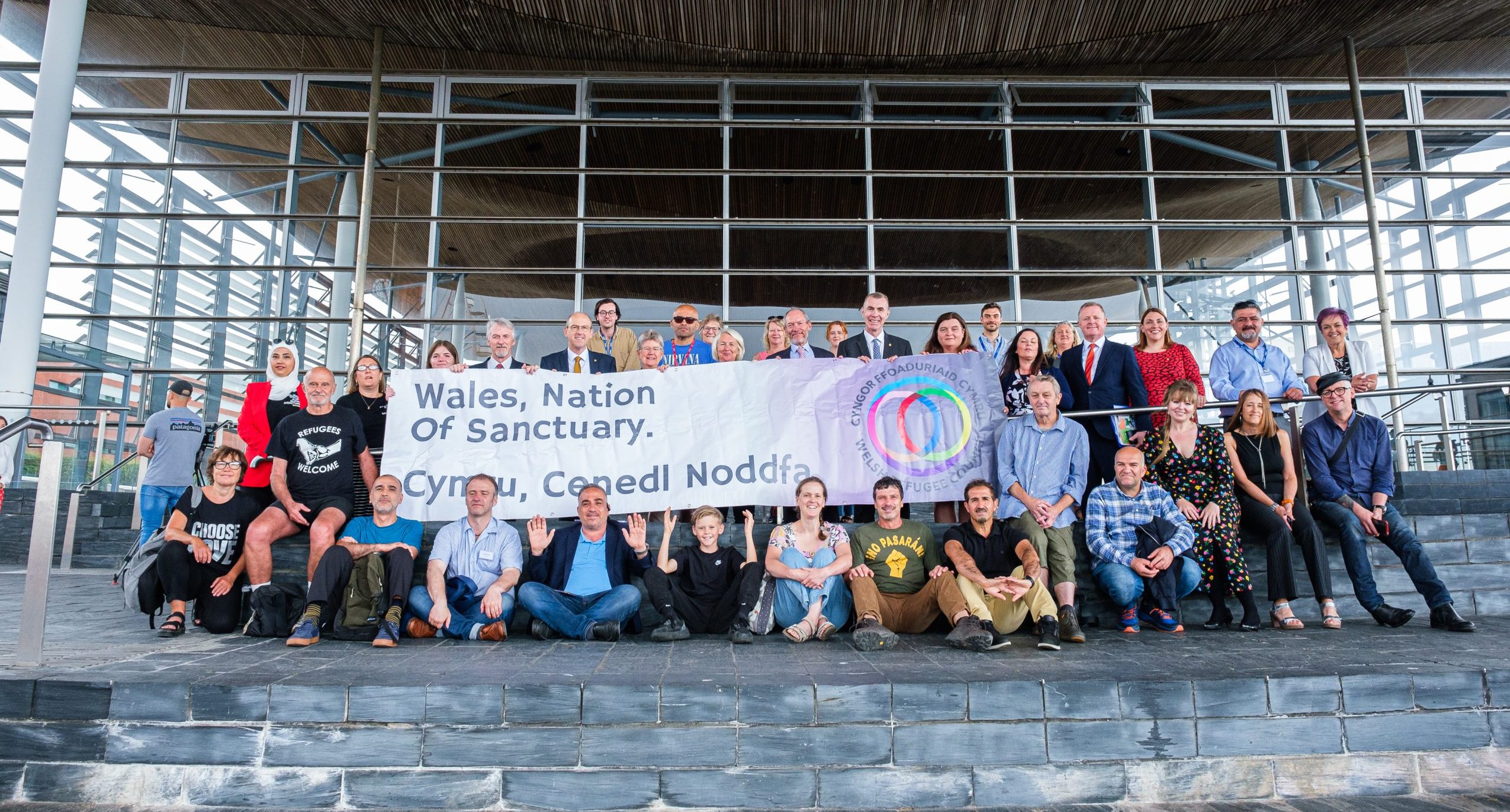 230620Senedd 002_N Treharne Group of people sat outside the Senedd.