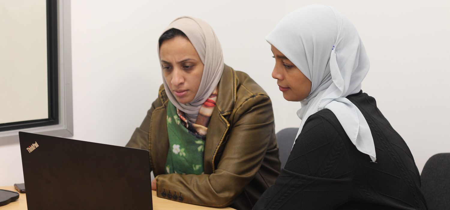 Two women working together at a laptop.