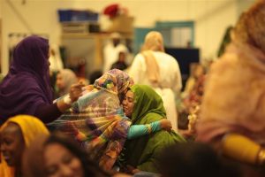 Two women hugging at an event with the Welsh Refugee Council.