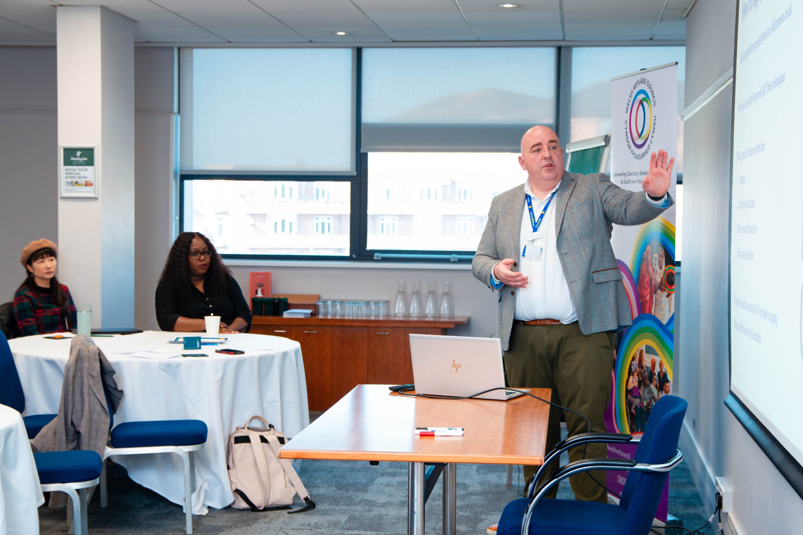 Welsh Refugee Council employability partner presents to a room of the employability programme participants.