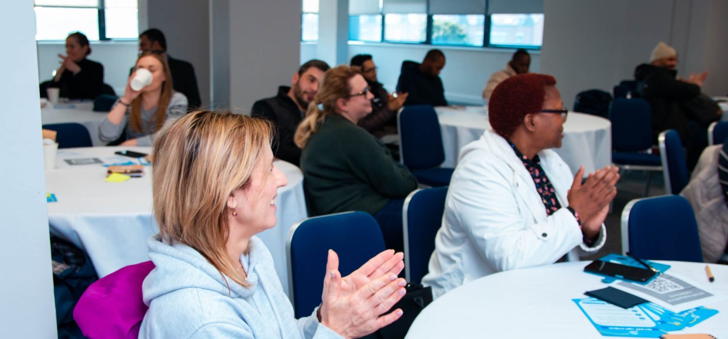 Women clapping at a Welsh Refugee Council employability event.
