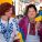 Two women hold Ukranian and Welsh flags and smile together.