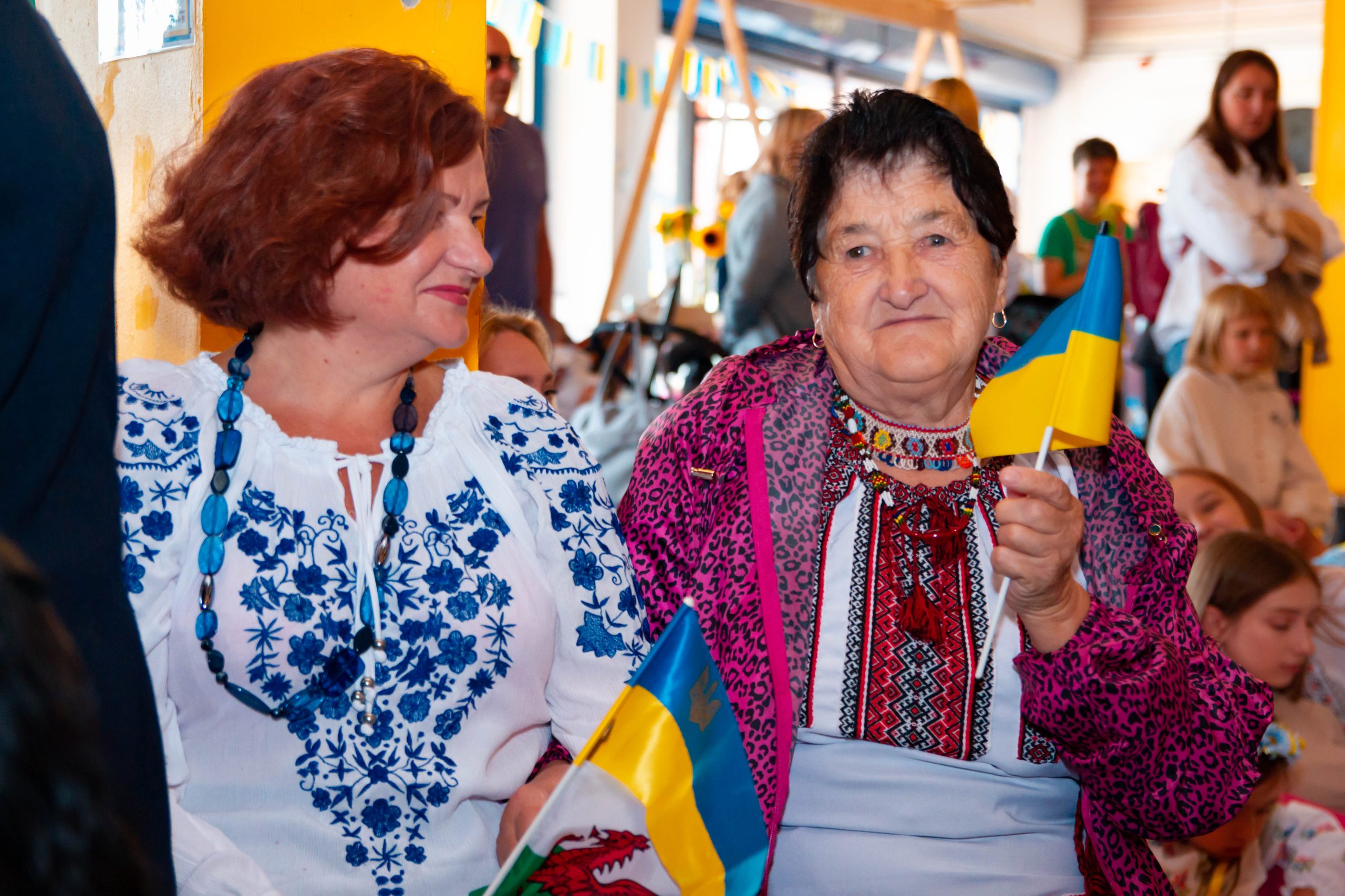 IMG_6287 Two women hold Ukranian and Welsh flags and smile together.