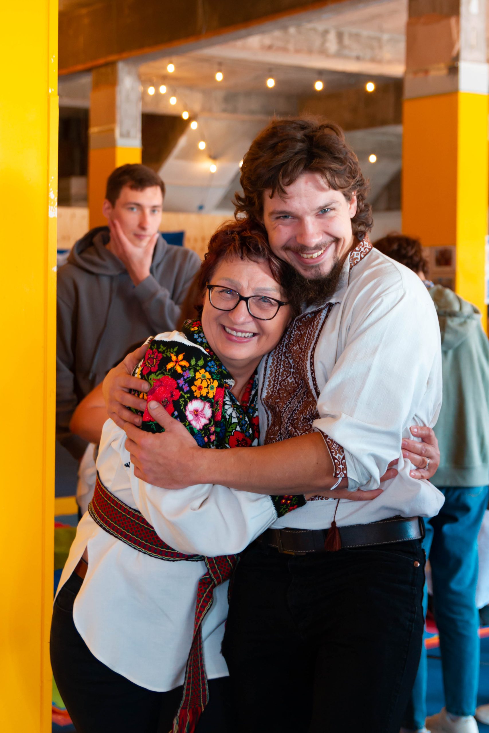 Two adults smiling and hugging together.