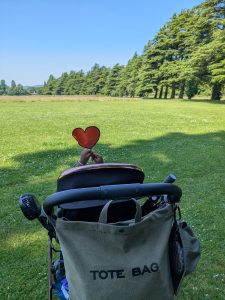 Child holding a orange heart above a buggy. 