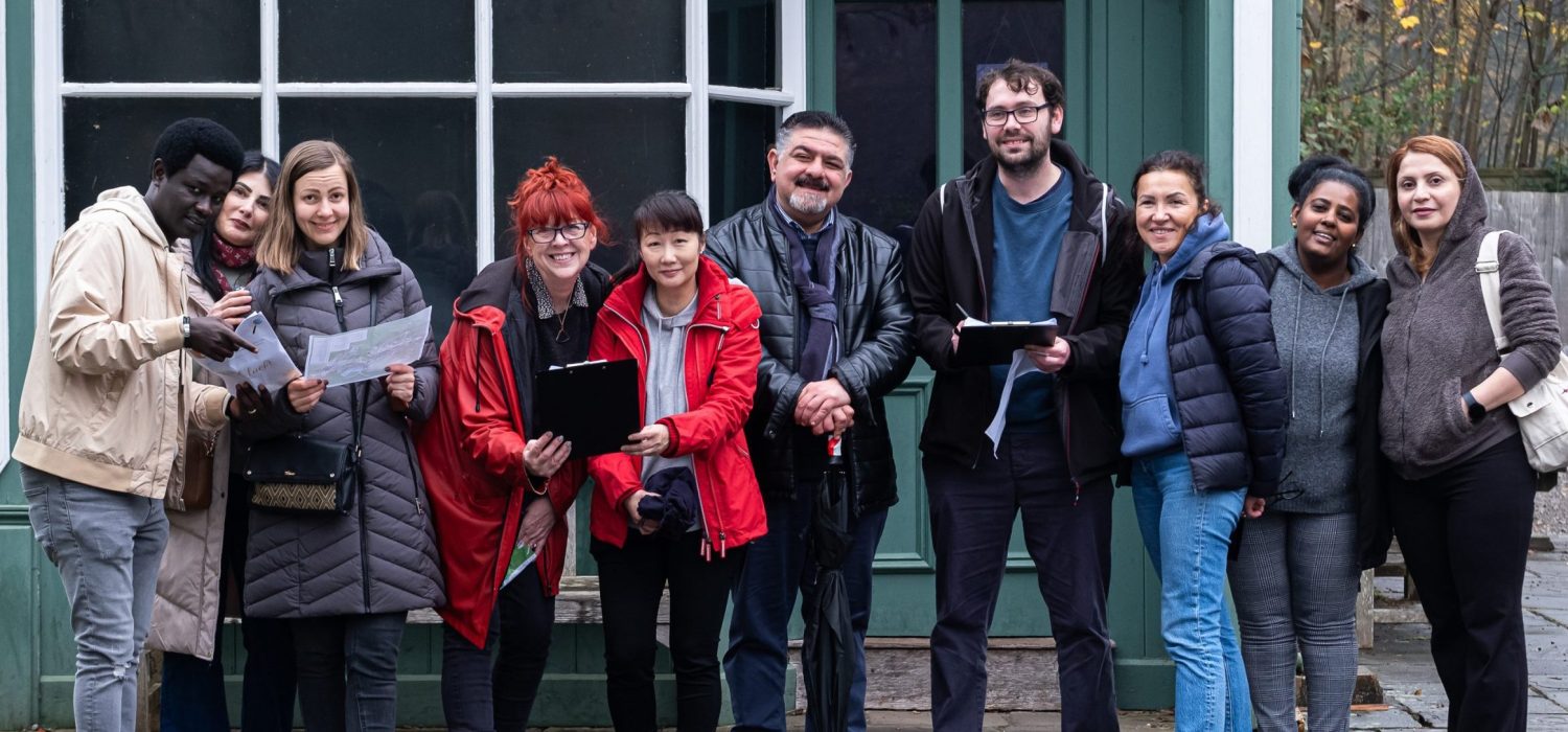 Welsh Refugee Council staff outside working as a team.
