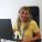 Welsh Refugee Council caseworker smiling and working on their laptop in the Cardiff office.