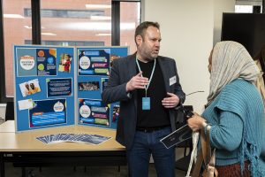 Welsh Refugee Council staff explaining the Sanctuary Coalition Cymru manifesto at an event.