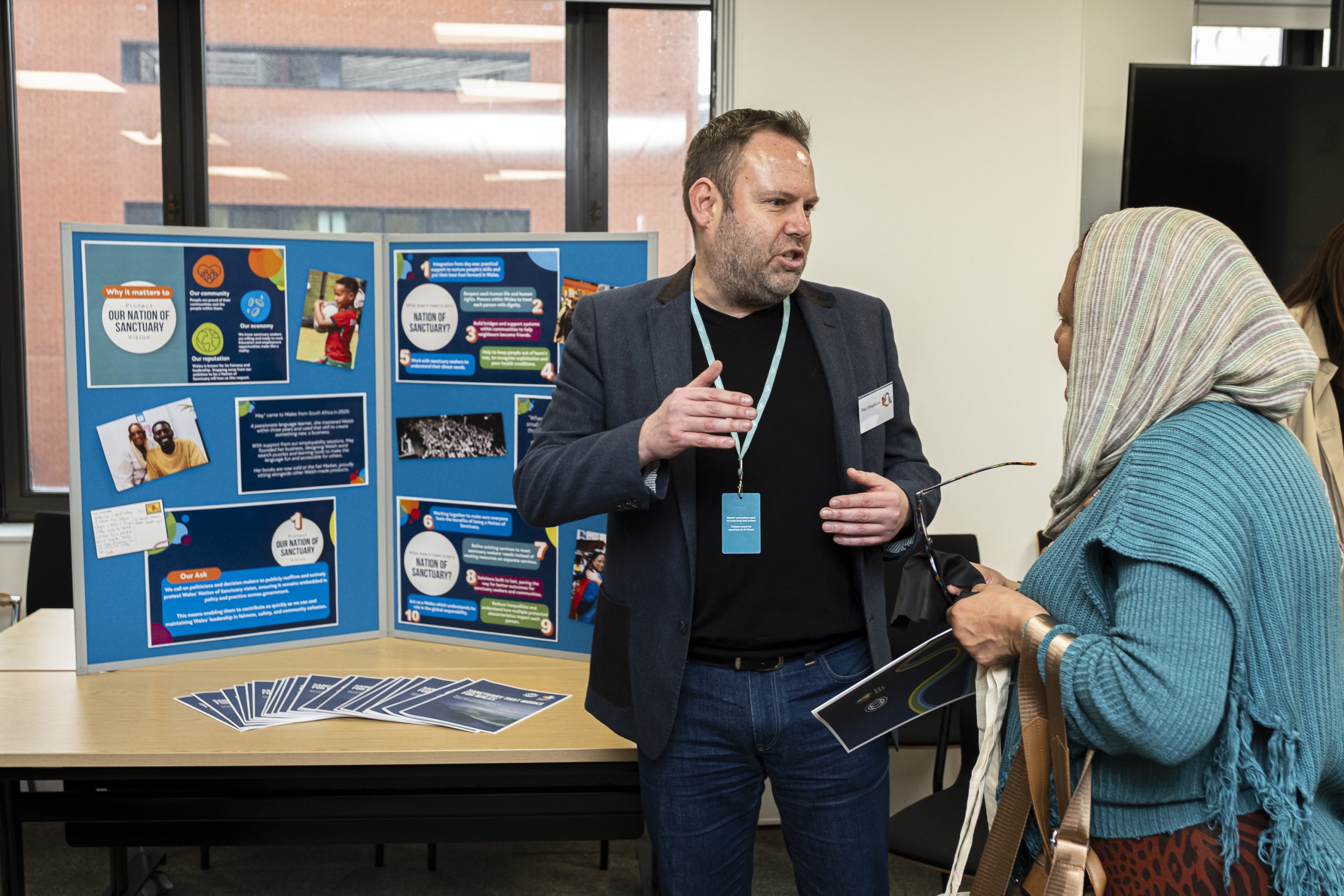 Welsh Refugee Council staff explaining the Sanctuary Coalition Cymru manifesto at an event.
