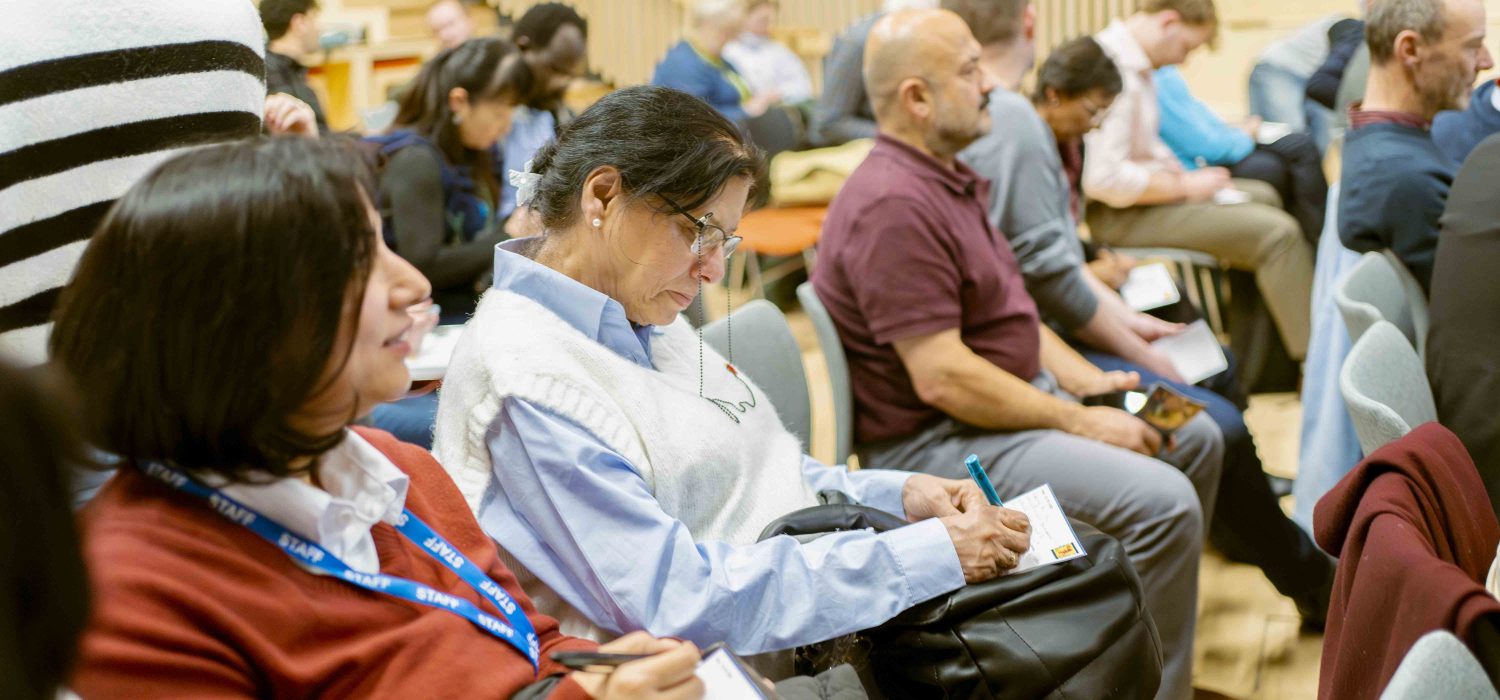Woman writing a message to their political representative at the Welsh Refugee Council annual general meeting.