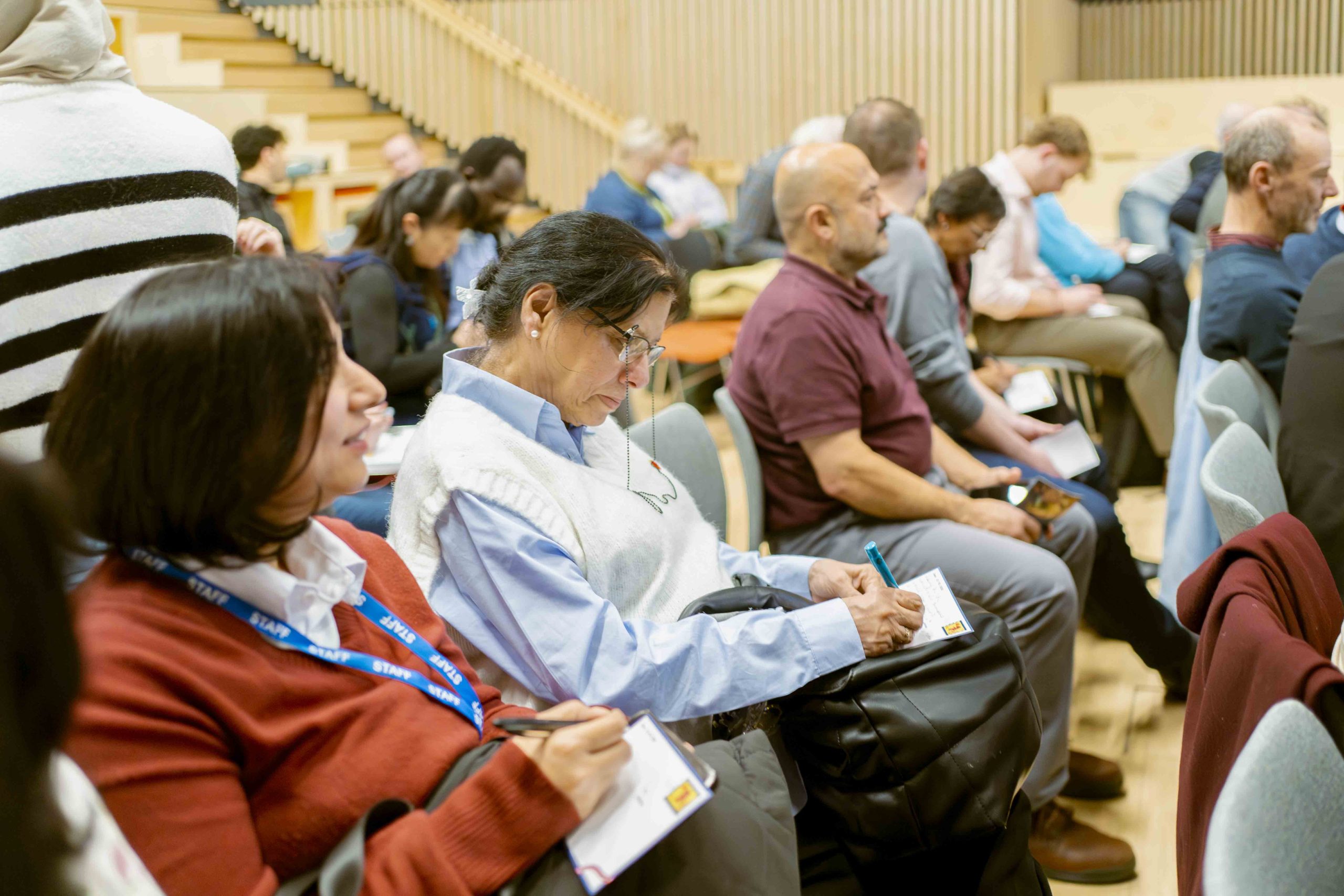 Woman writing a message to their political representative at the Welsh Refugee Council annual general meeting.