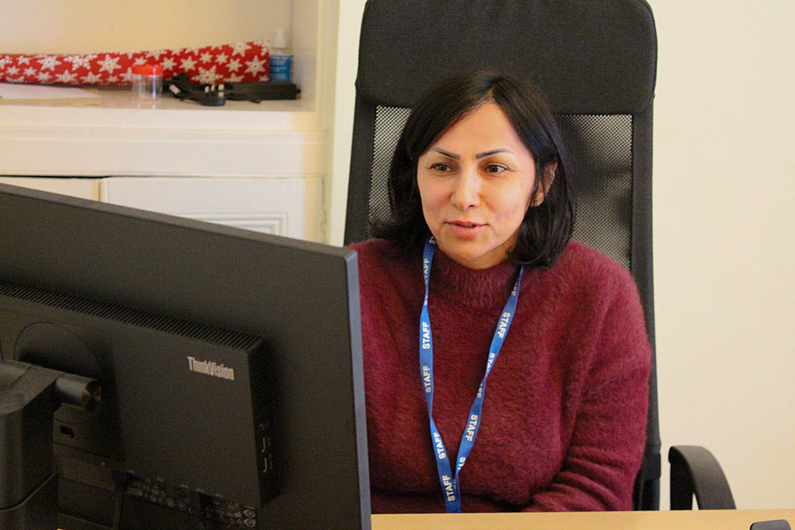 Welsh Refugee Council staff working at a computer in the charity office.