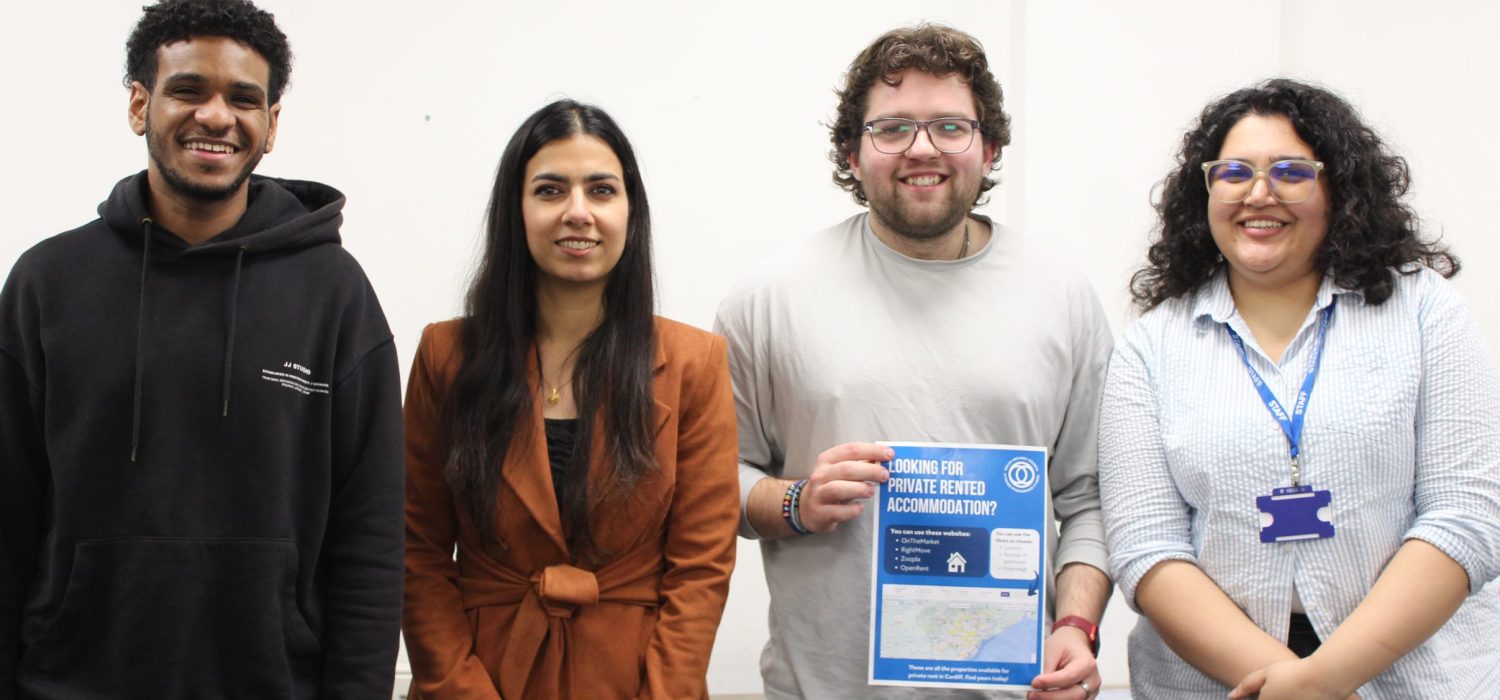 Welsh Refugee Council team members smiling and sharing information about housing in Wales.