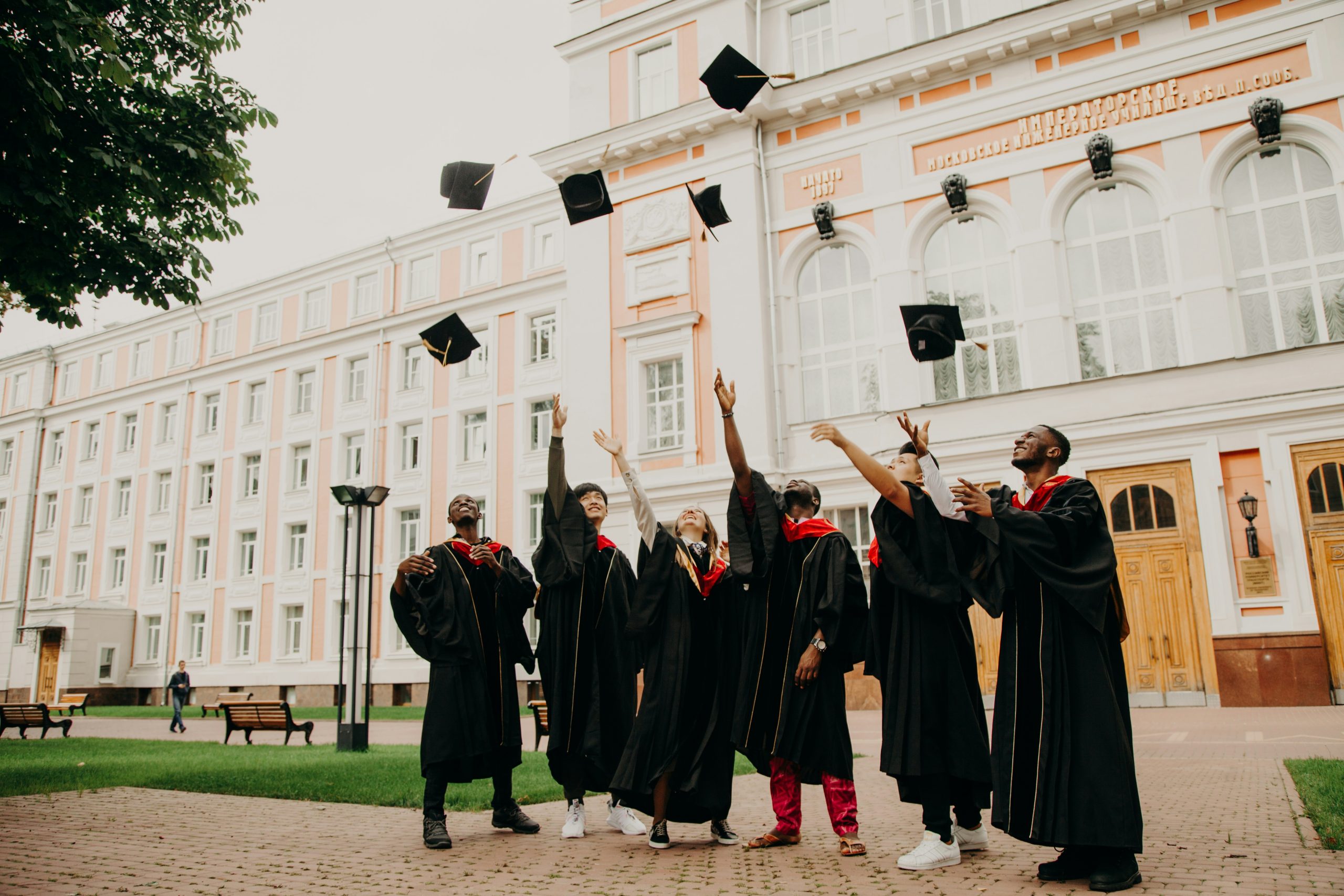 Group of students share graduation celebrations outside a university.