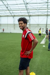 Smiling football player at Refugee Week tournament.