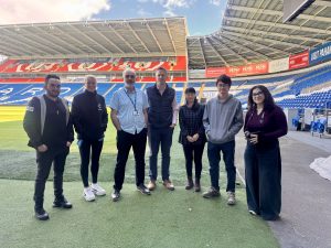 Team stood at Cardiff City Football stadium. 