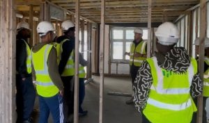A group of people wearing high vis at a building site visit. 