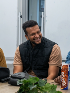Man smiling at a Education and Employability workshop with the Welsh Refugee Council. 