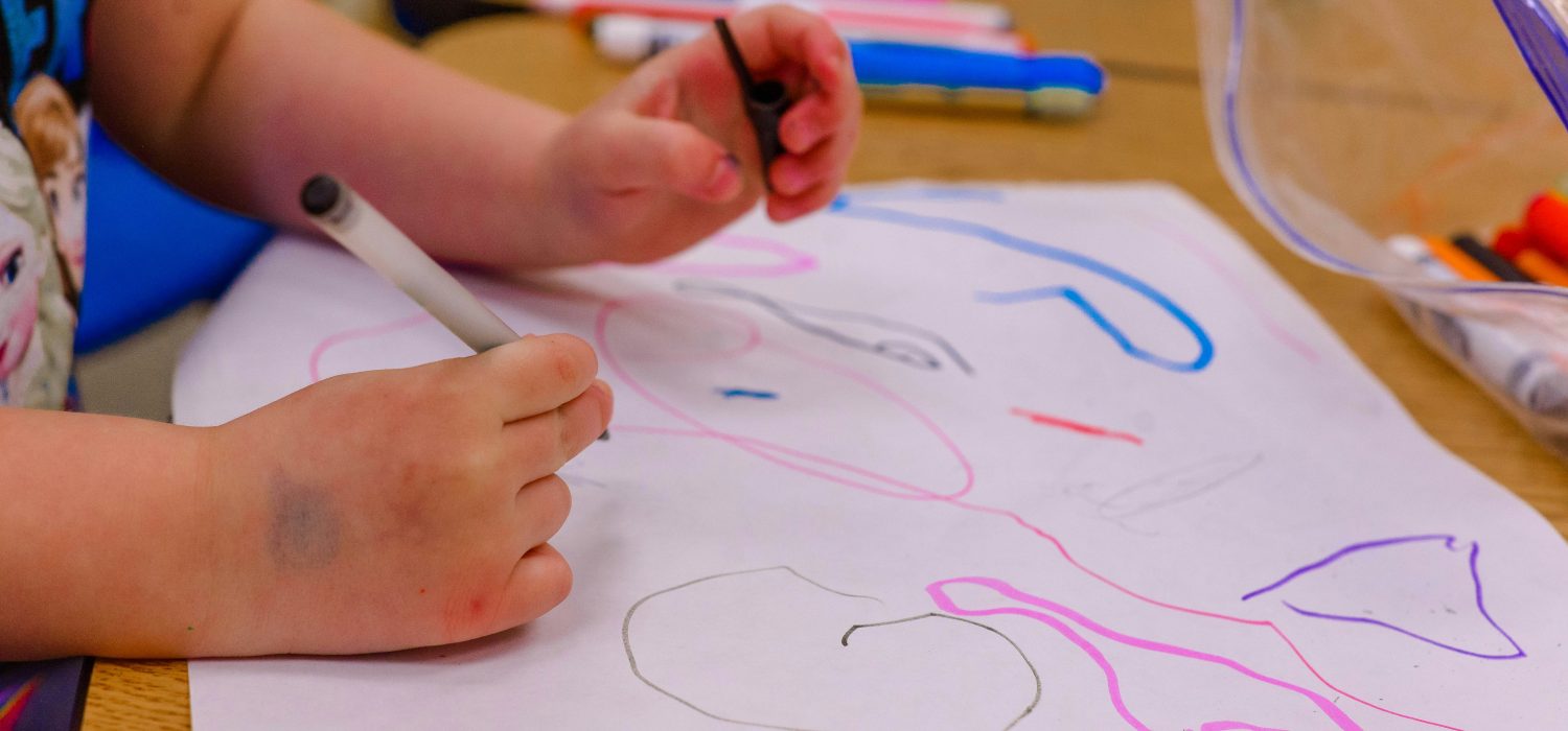 Child's hands drawing.